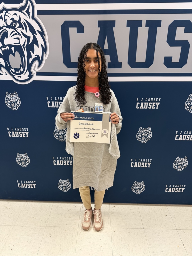 Student holding t-shirt and certificate