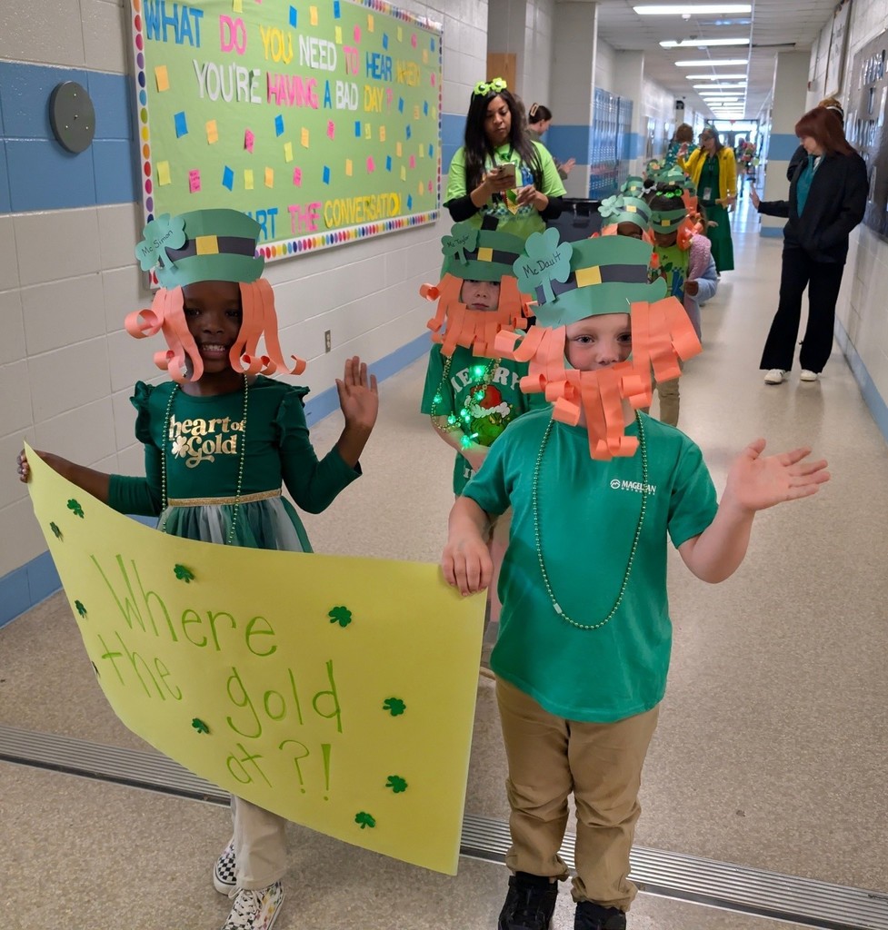 Two students dressed as leprechauns hold a sign that reads "Where the gold at?"