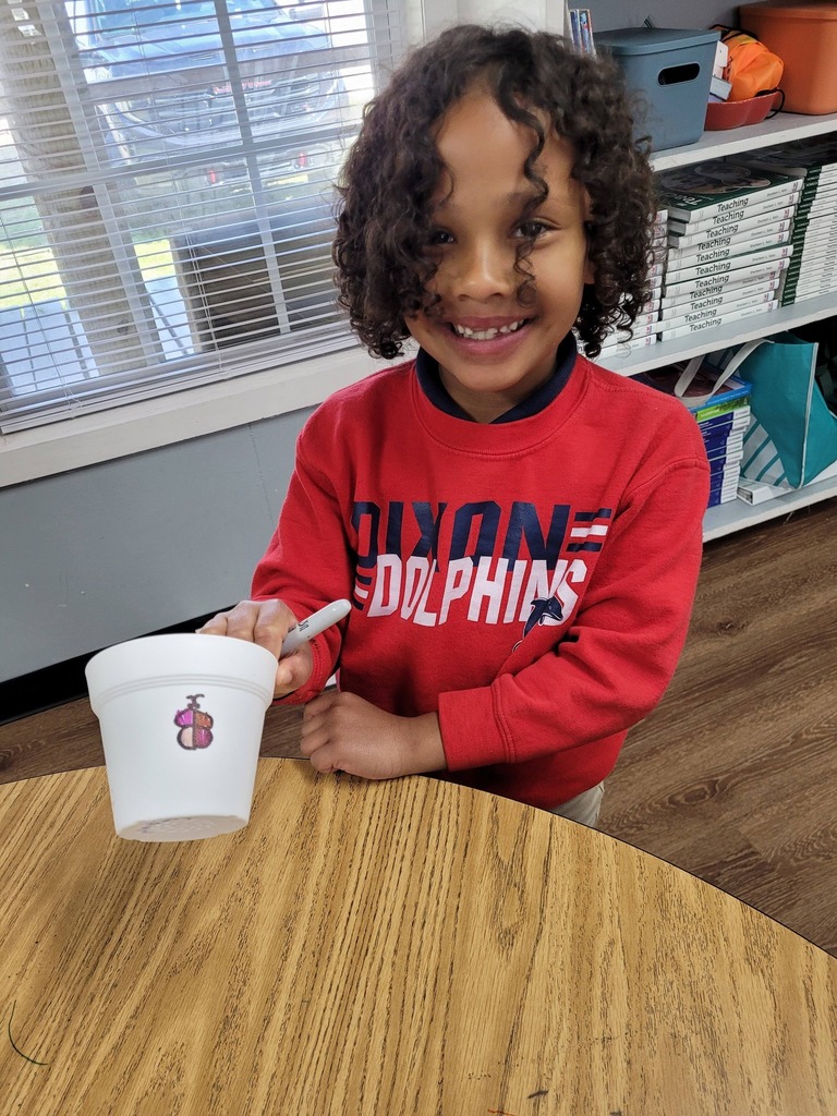 A Dixon Elementary first-grader holds a styrofoam cup with a drawing of a butterfly on it
