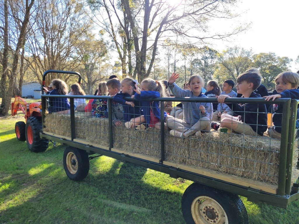 Students wave from a hayride
