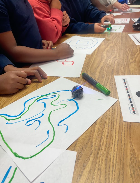 A micro robot on a sheet of paper,  moving along a path students created for it to follow 