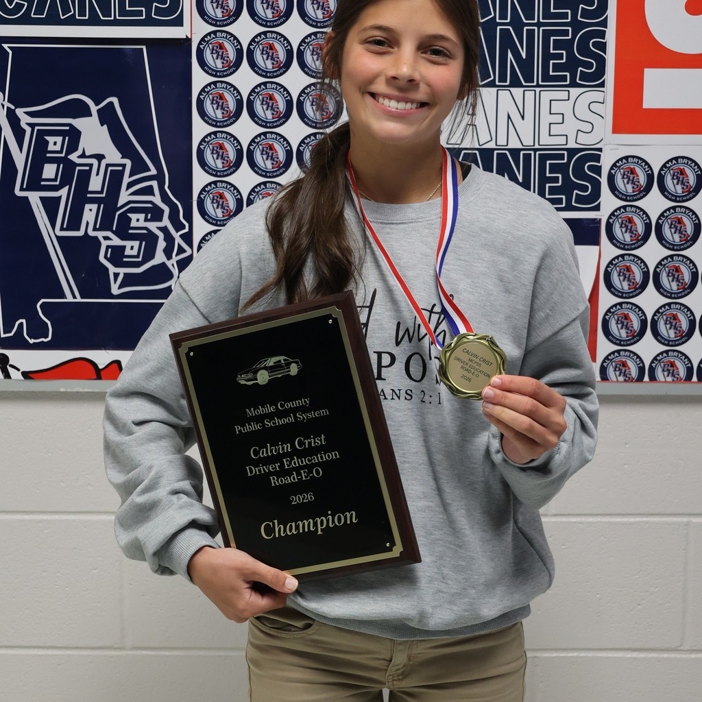 Rosalie Miller holds a plaque and wears a medal