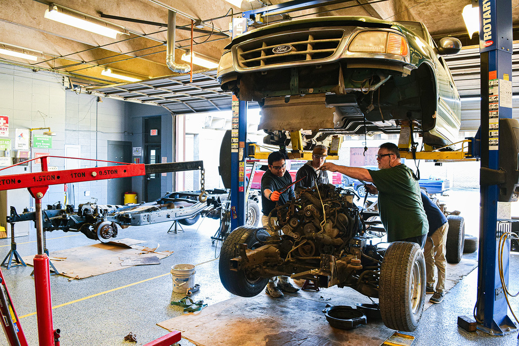 automotive students removing motor from frame
