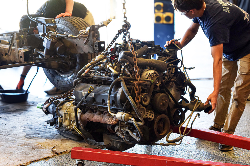 automotive students removing motor from frame
