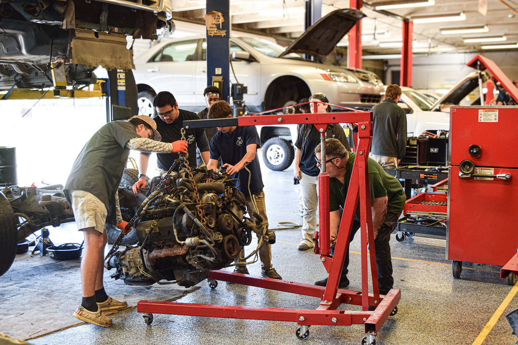 automotive students removing motor from frame