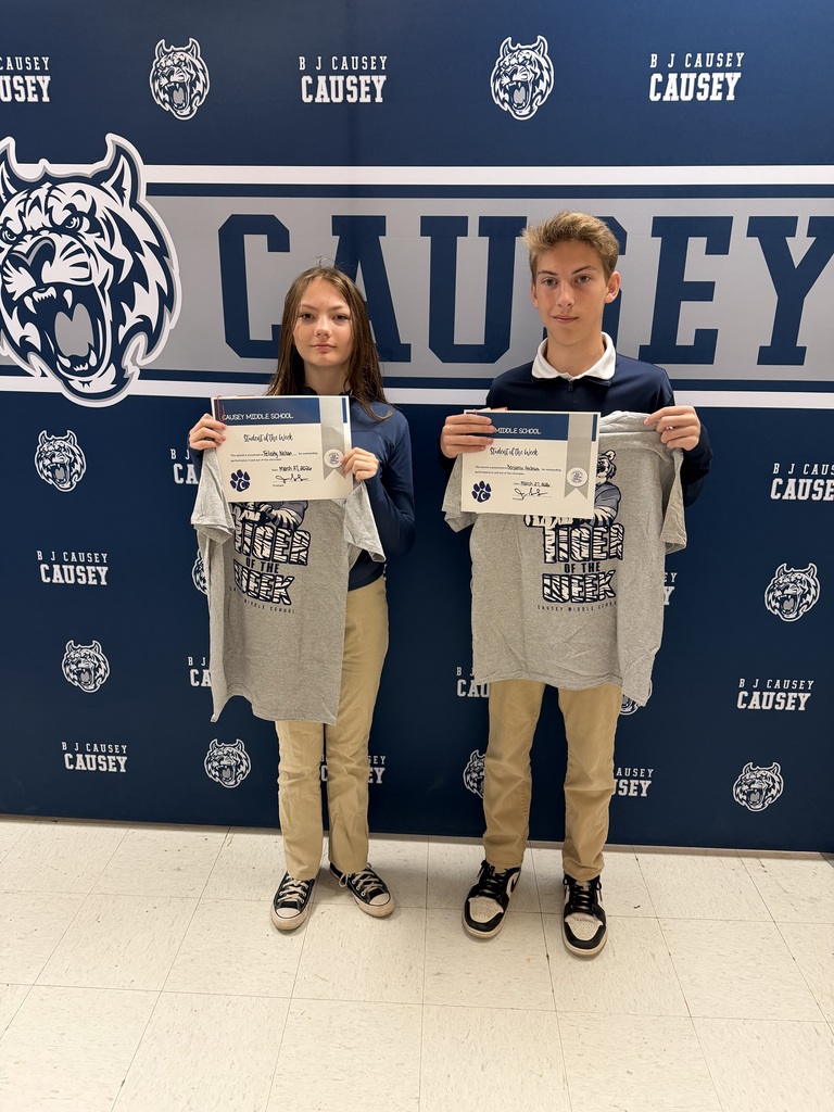 2 students holding up t-shirts and certificates