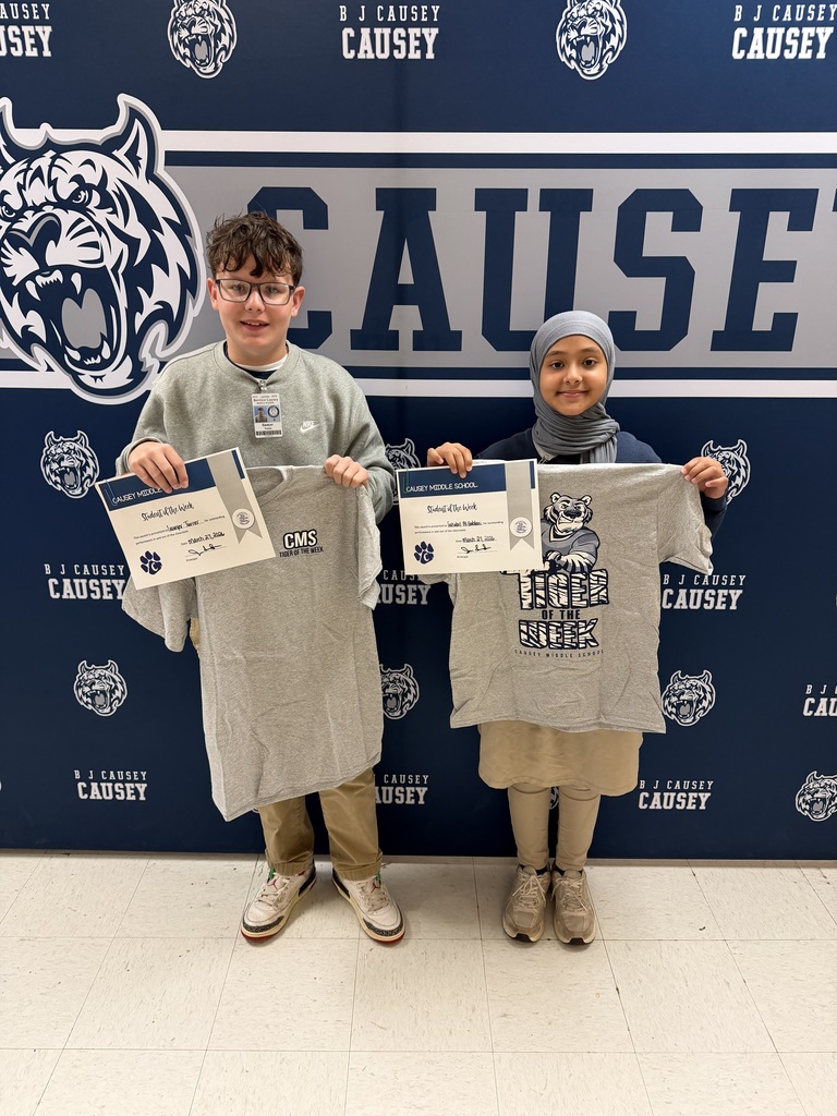 2 students holding up t-shirts and certificates