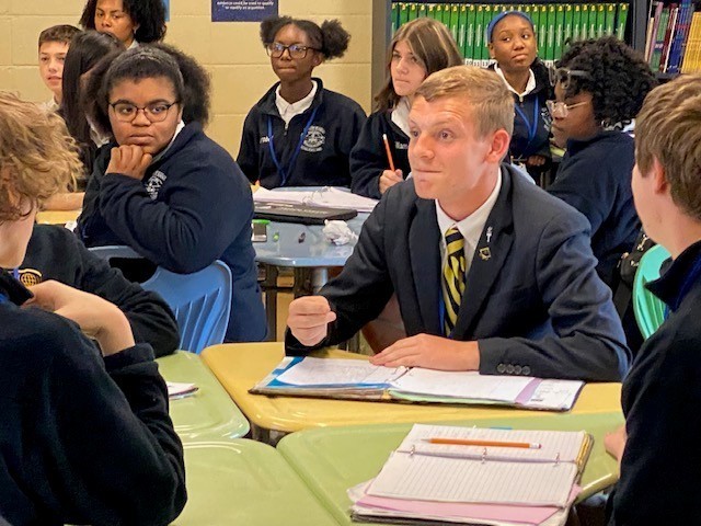 Ben Stringfellow, sitting at a desk, reacts to being named a Learning Leading Award winner