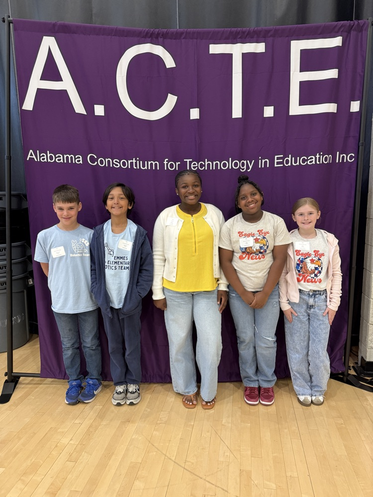 five students smiling in front of ACTE banner