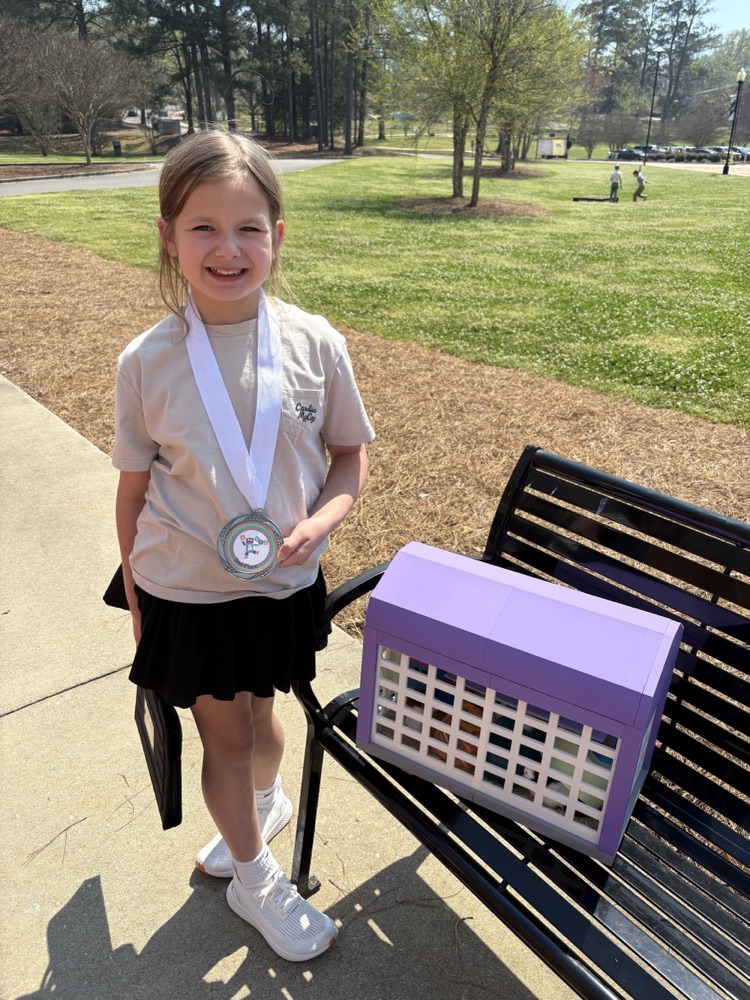 female student outside standing by 3D printed hamster cage