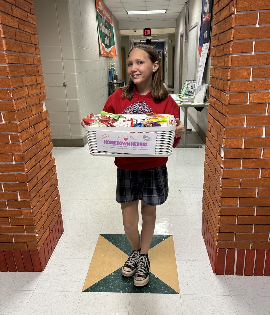 Josephine Crane, standing in a hallway holding a basket