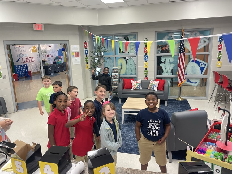 a groups of students make a line to get prizes from the prize cart