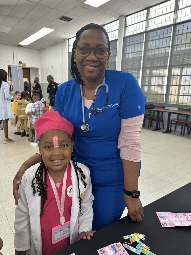 A girl dressed like a nurse stands with a real nurse