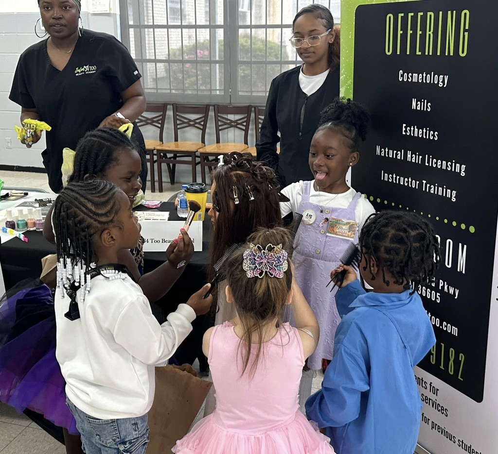 Five preschool girls work on the hair of a mannequin