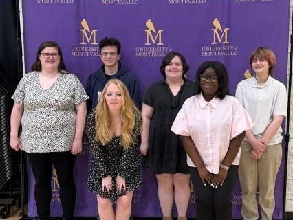 A group of students in front of a Montevallo backdrop