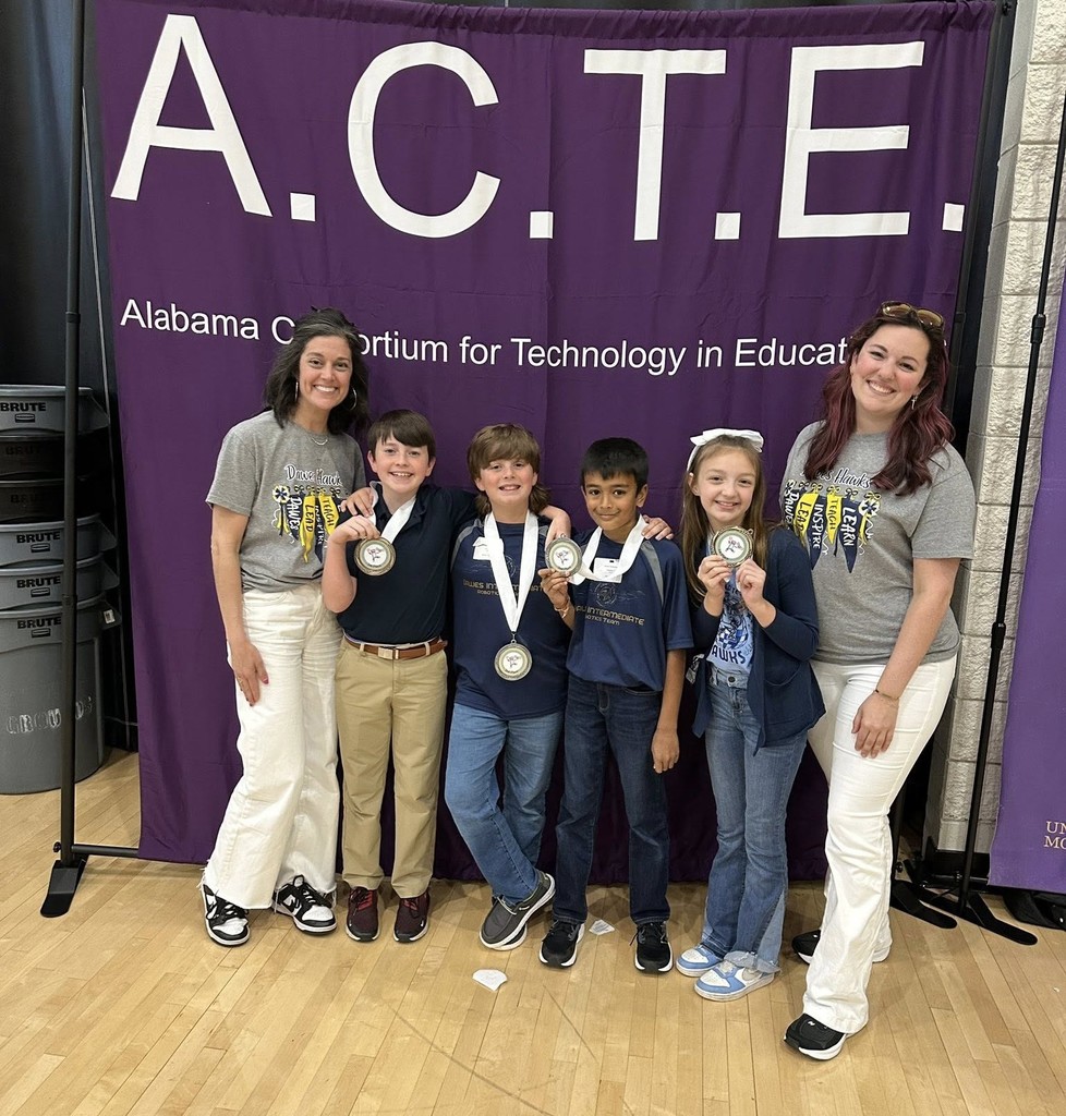Four students and two teachers in front of an ACTE backdrop