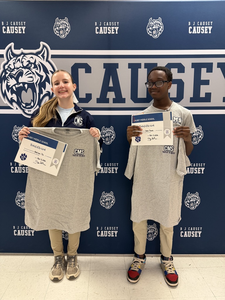 2 students holding up t-shirts and certificates