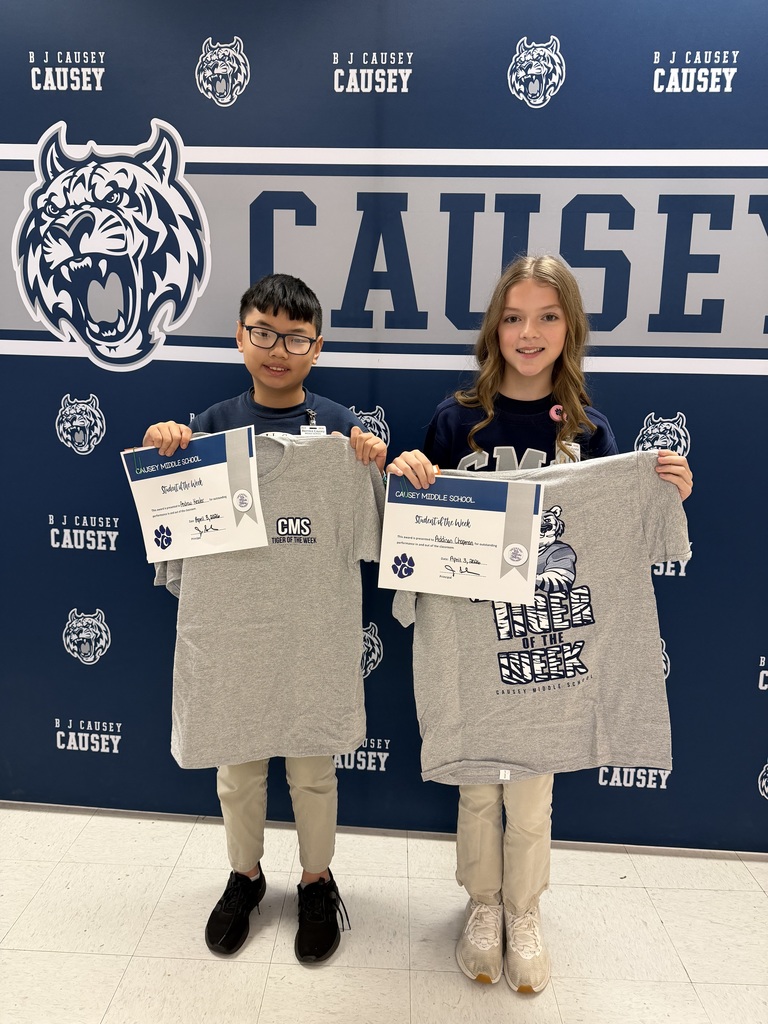2 students holding up t-shirts and certificates