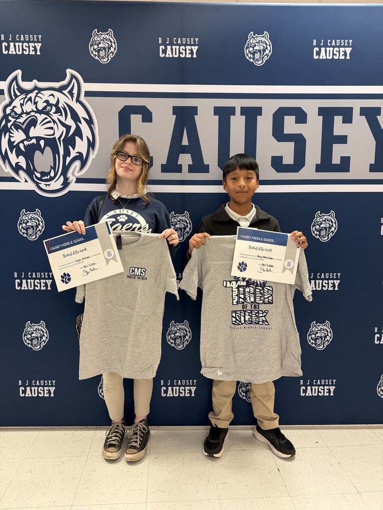 2 students holding up t-shirts and certificates