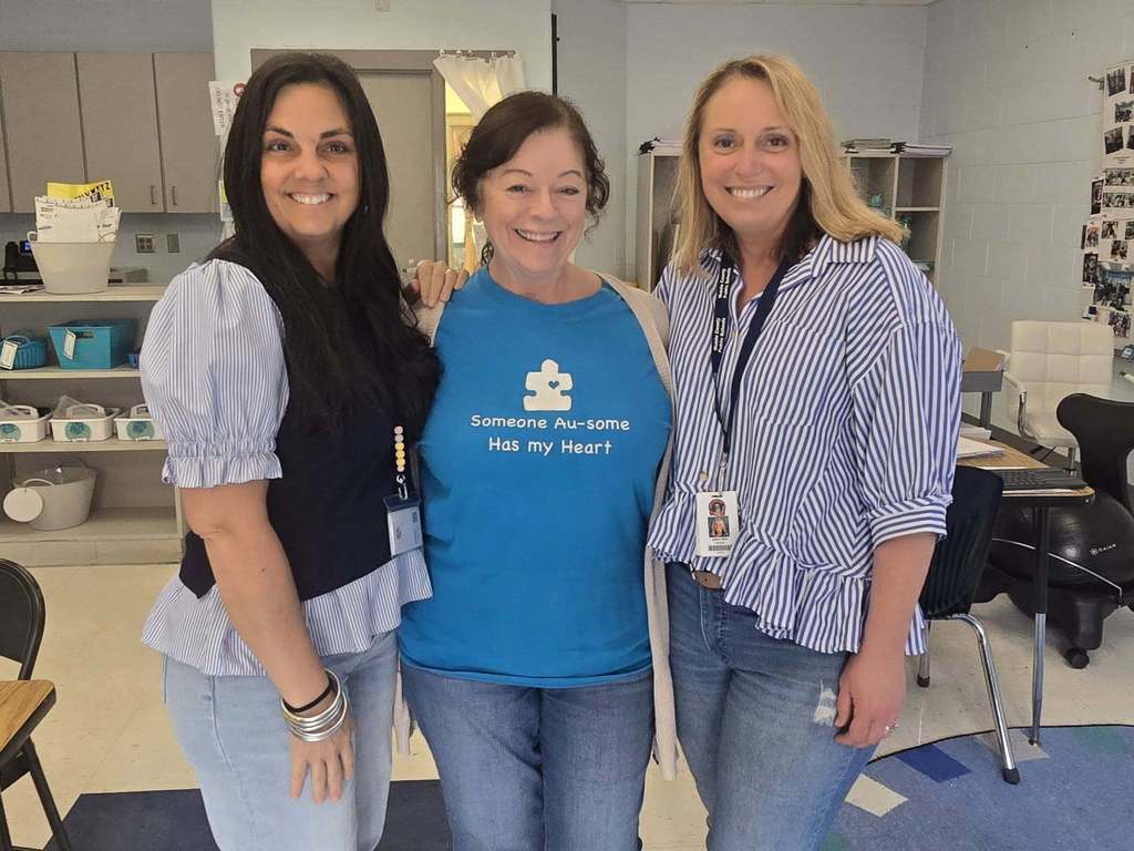 Three teachers, one of whom is wearing a T-shirt that reads "Someone Au-some has my heart"
