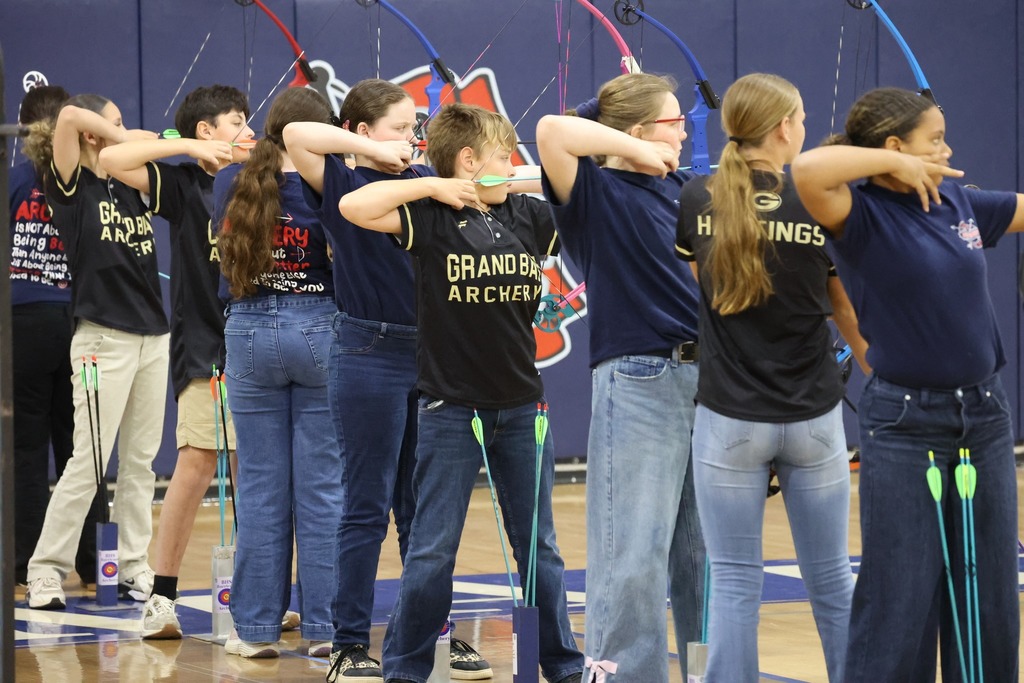 A line of middle school archers take aim