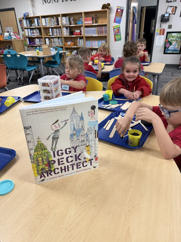 pre-K students building with Play-Doh and craft sticks in the library
