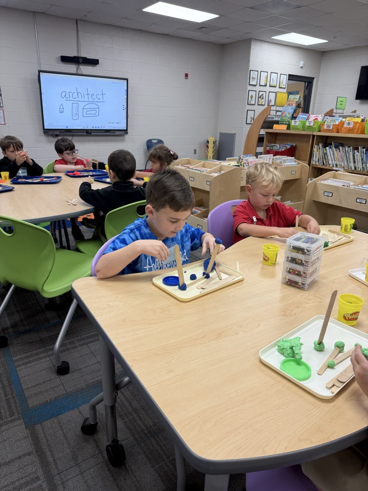 pre-K students building with Play-Doh and craft sticks in the library