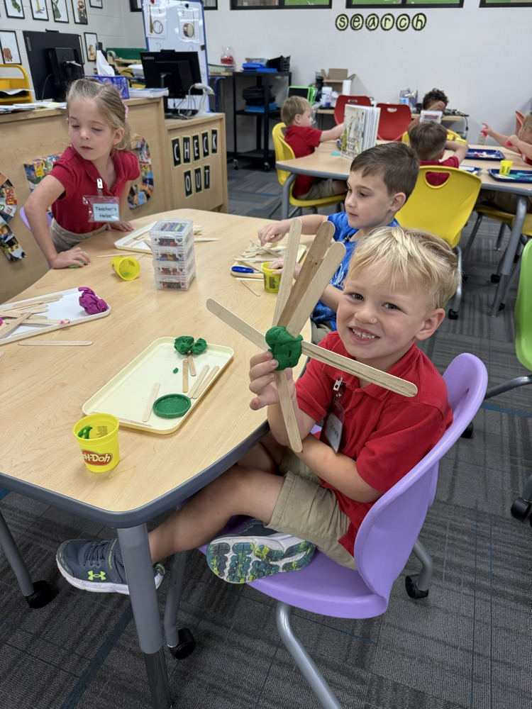 pre-K students building with Play-Doh and craft sticks in the library