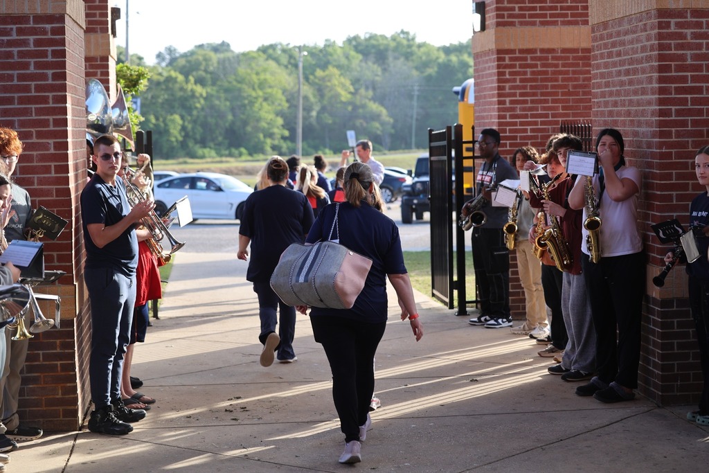 Alma Bryant band members line a walkway as students walk down it