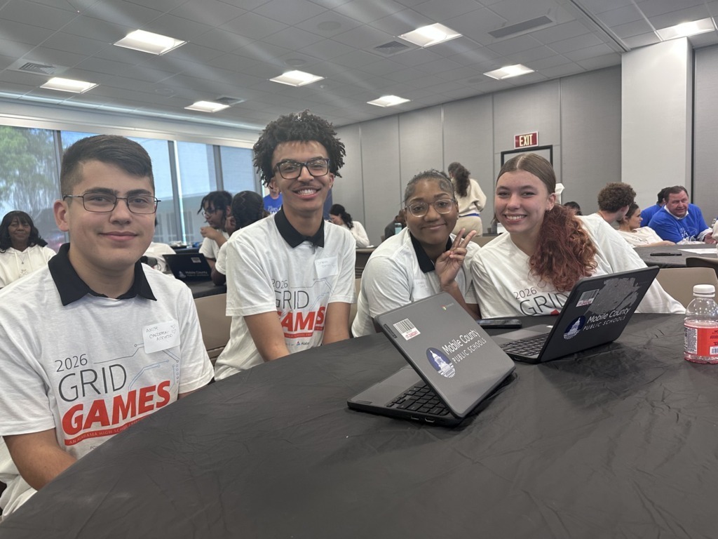 Four Davidson High students sitting at a table with open laptops