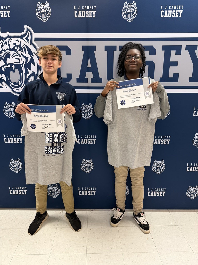 2 students holding up t-shirts and certificates