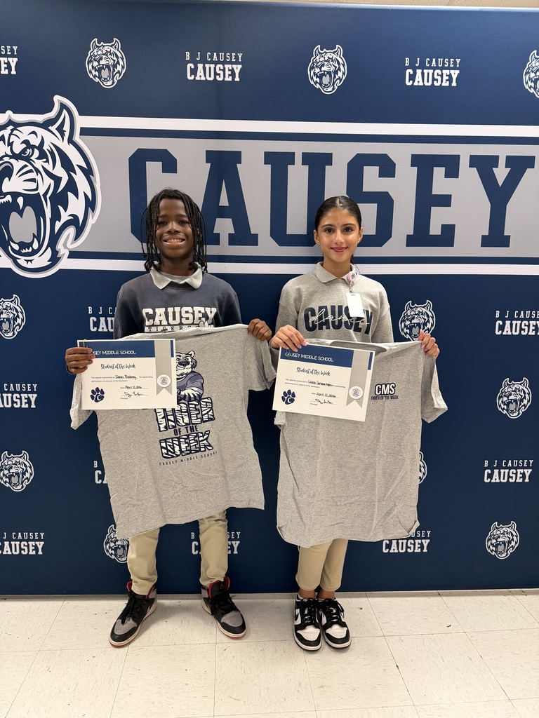 2 students holding up t-shirts and certificates