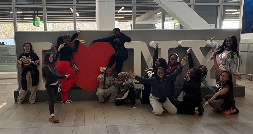 Theatre and choir students posing with I Love New York sign.
