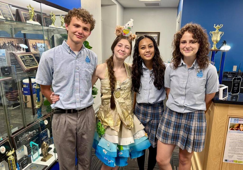 Three Barton Academy students, one of whom is wearing a handmade dress