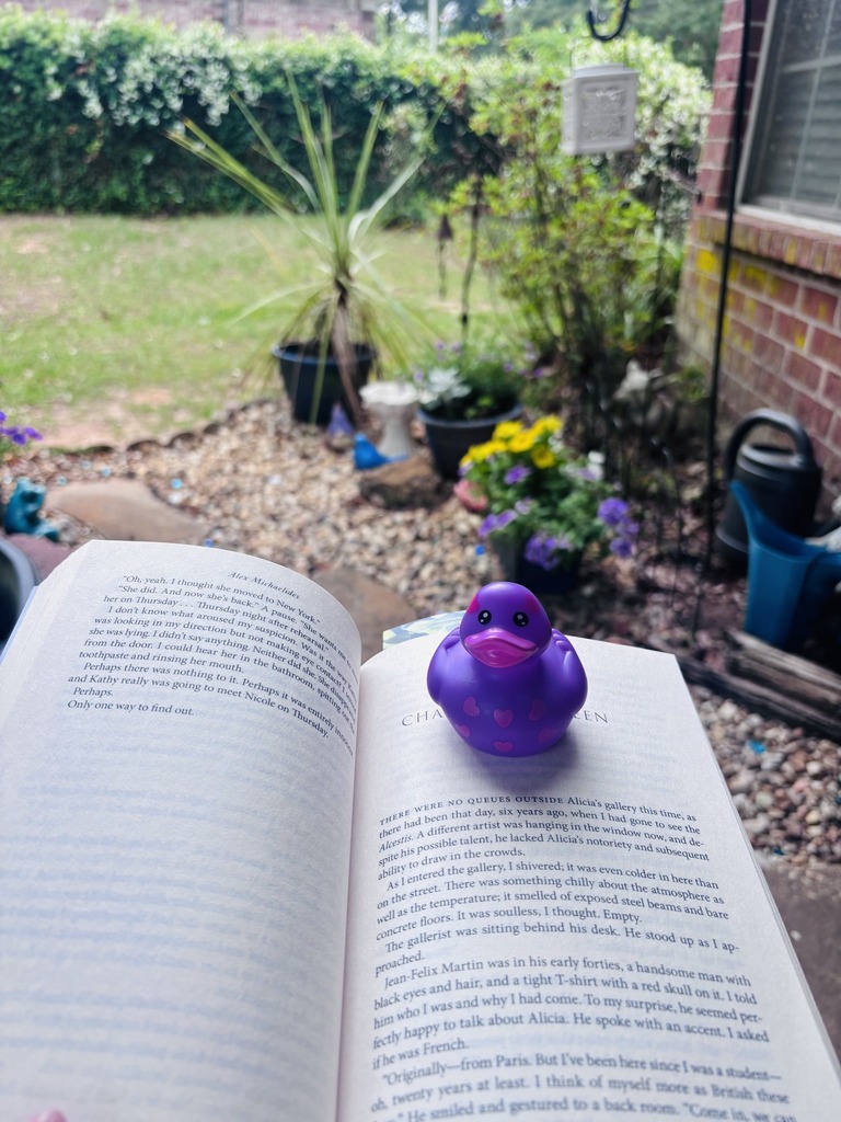 A rubber duck sitting atop an open book