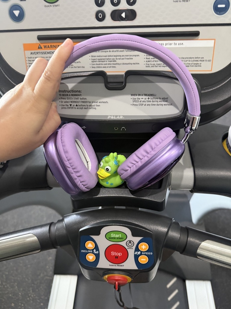 A pair of headphones resting on a rubber duck perched atop a spin cycle