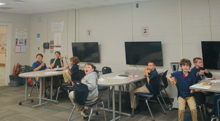 puzzle club students holding up pieces of pizza 