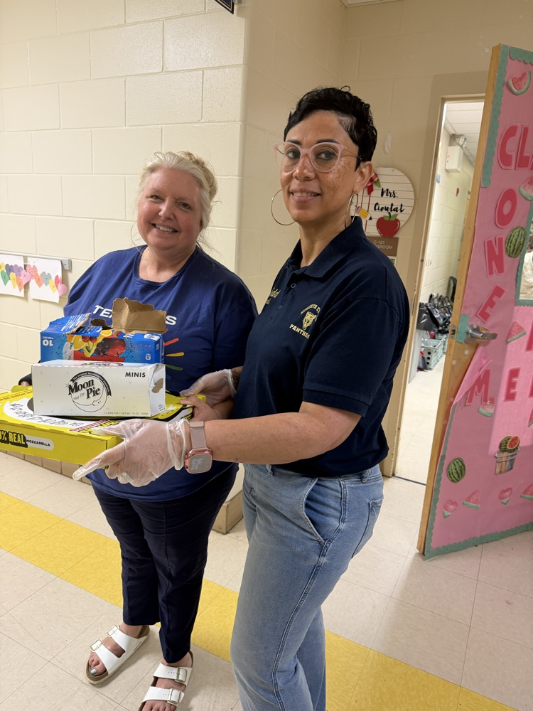 Mrs. Kidd giving pizzas to a teacher 