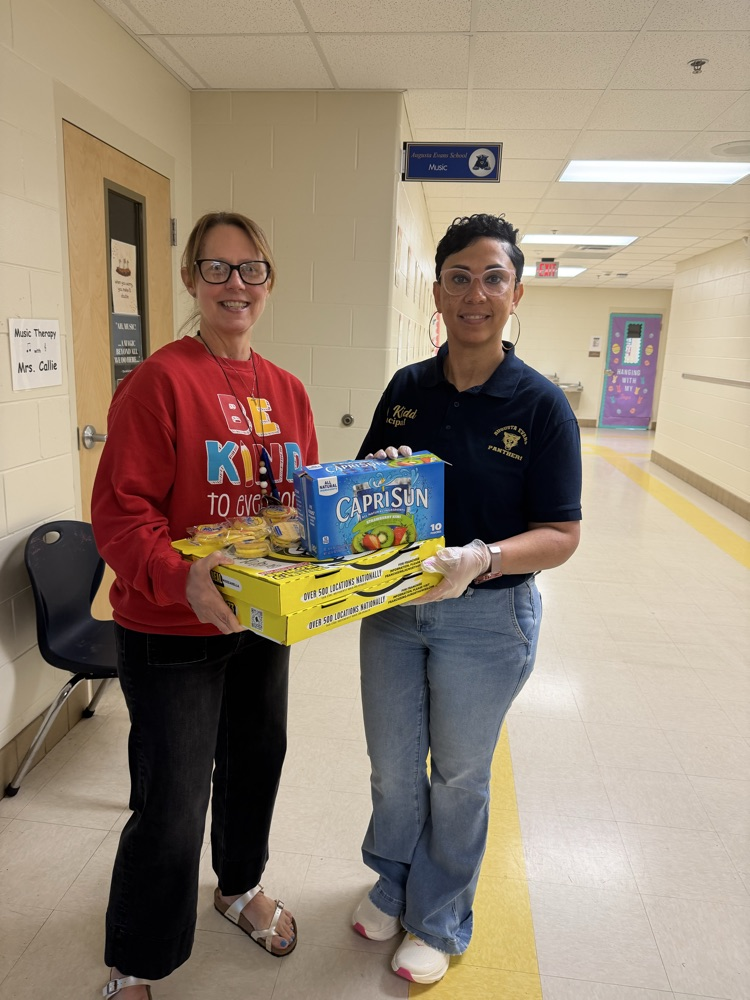 Mrs Kidd giving pizza and drinks to a teacher 