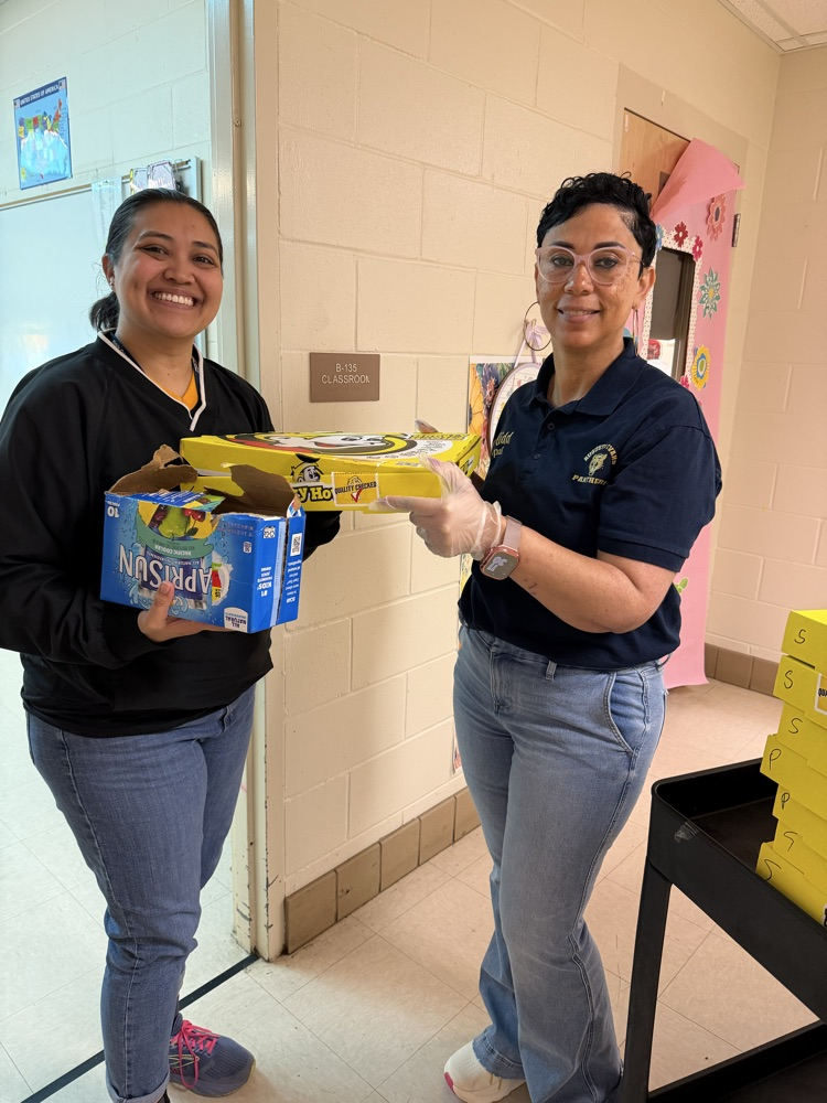 Mrs Kidd giving pizza and snacks to a teacher 