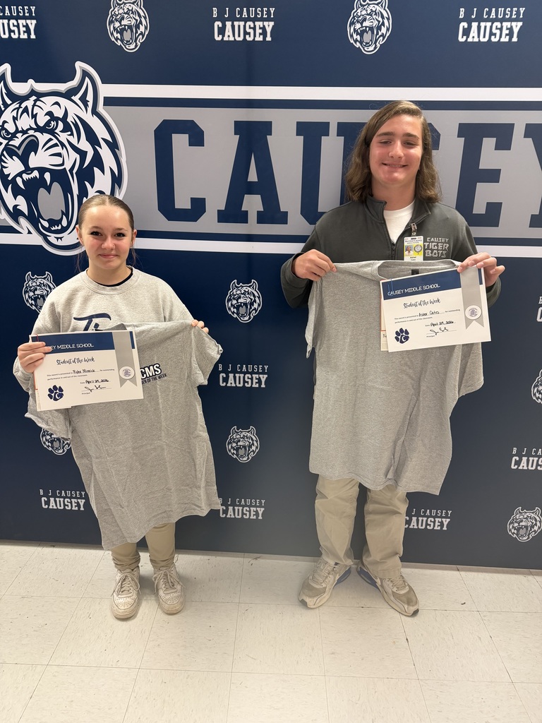Students holding t-shirts and certificates
