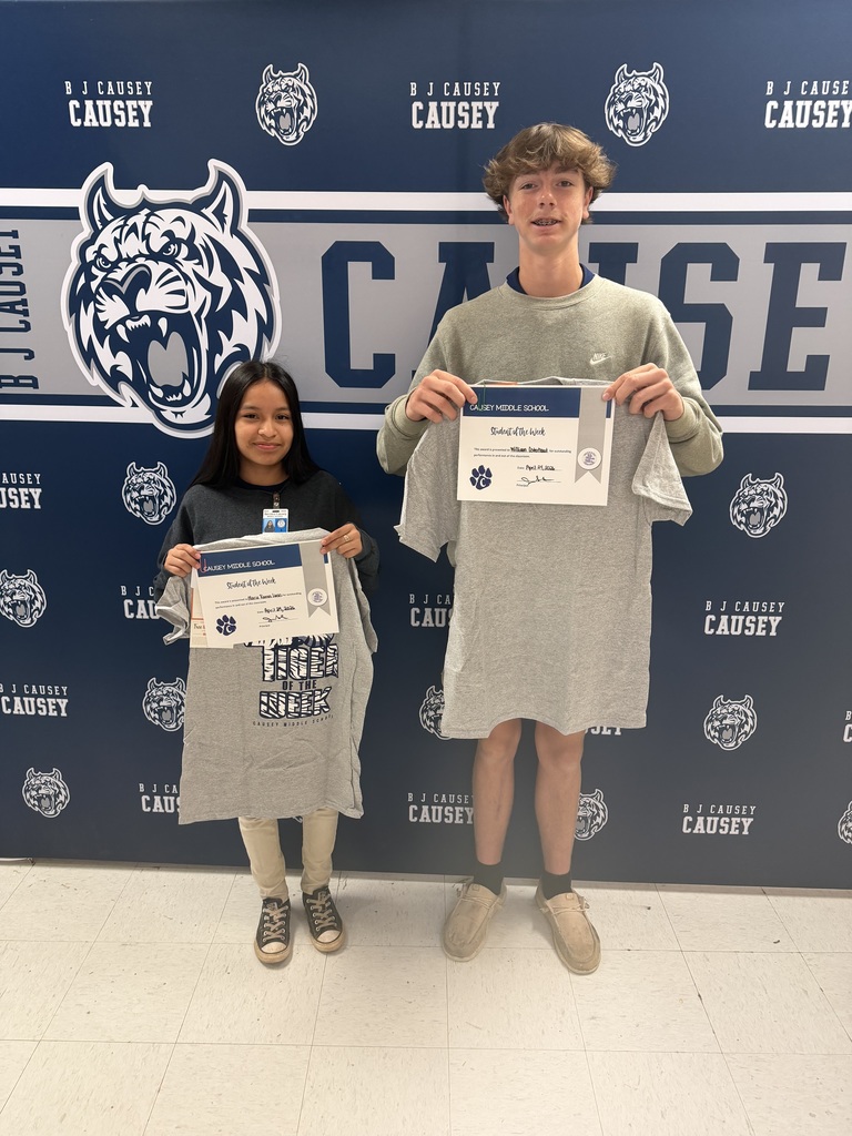 Students holding t-shirts and certificates
