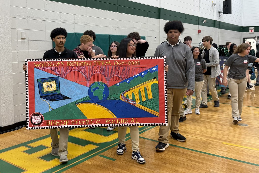 A group of students carrying a banner into a gymnasium