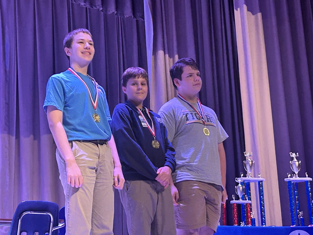 Group of students on stage with medals