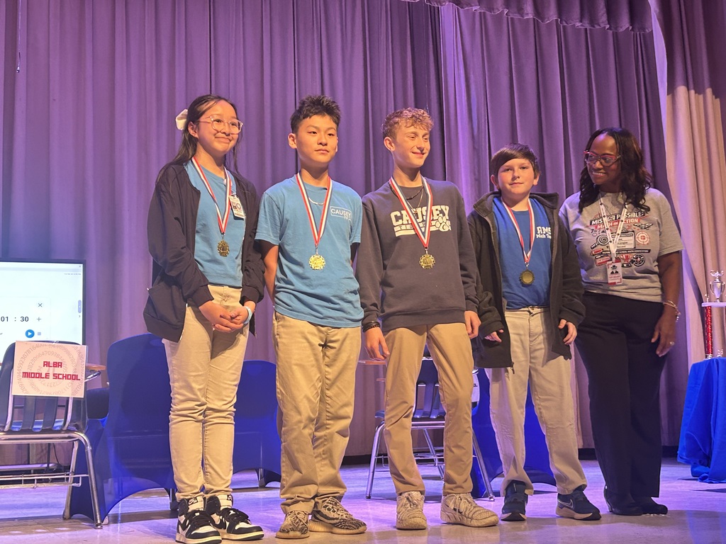 Group of students from math team on stage with medals