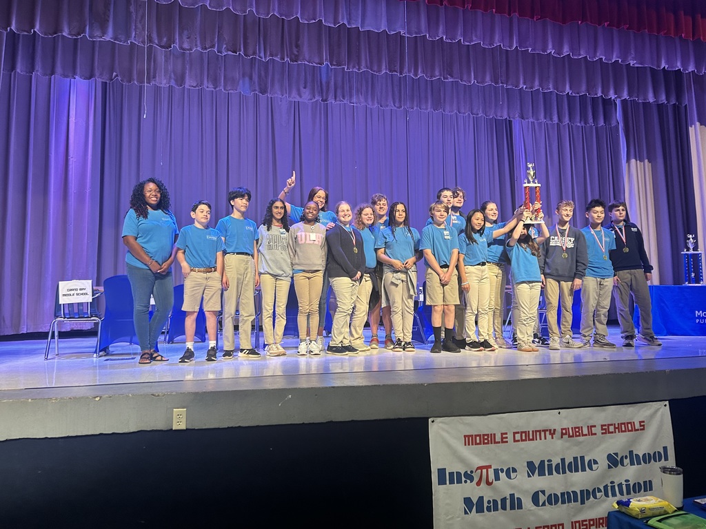 Math team on stage with winning trophy