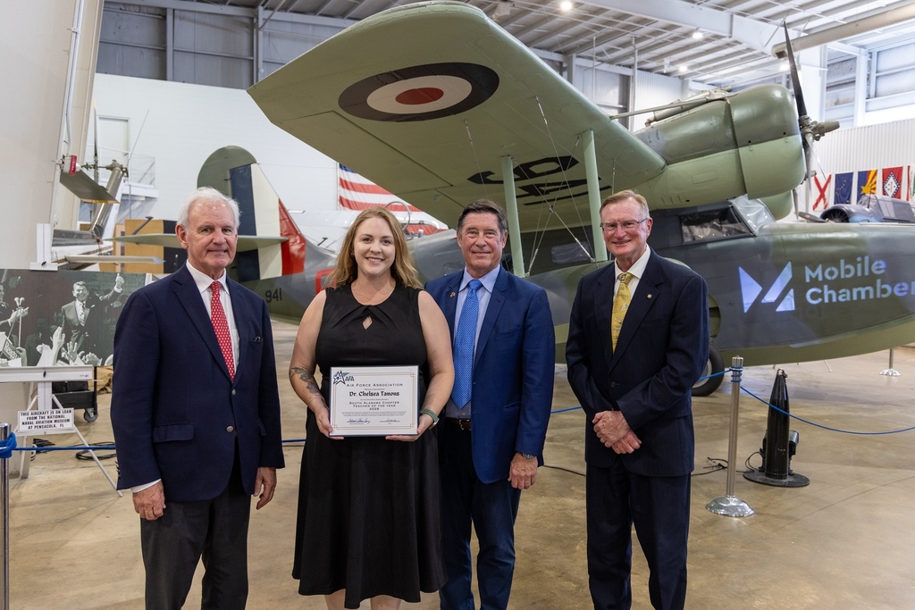 Dr. Chelsea Tanous holding a certificate and standing with Chamber officials