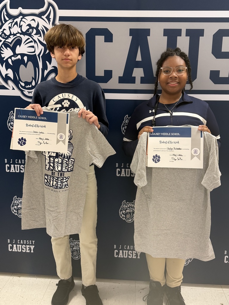 2 students holding up t-shirts and certificates