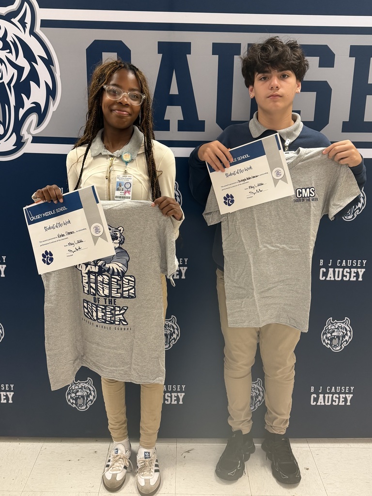 2 students holding up t-shirts and certificates