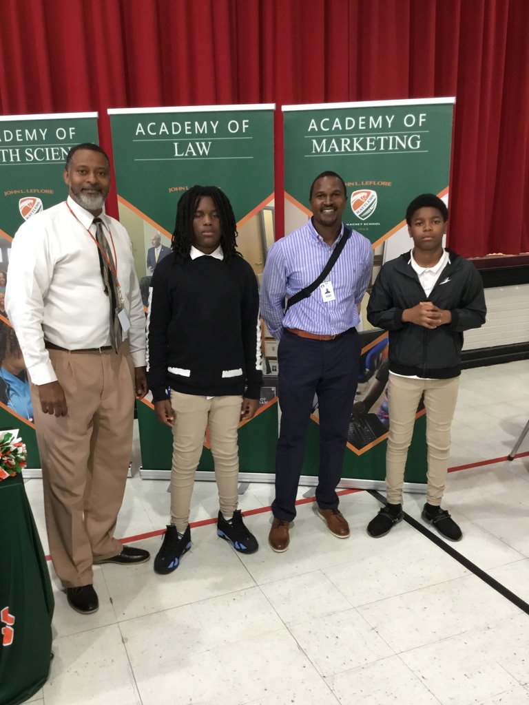 LeFlore High School representatives and several of Booker T. Washington Middle School students are standing in front of LeFlore High School backdrop.